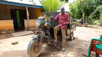 Cocoa farmer sitting on a motor tricycle in Côte d'Ivoire